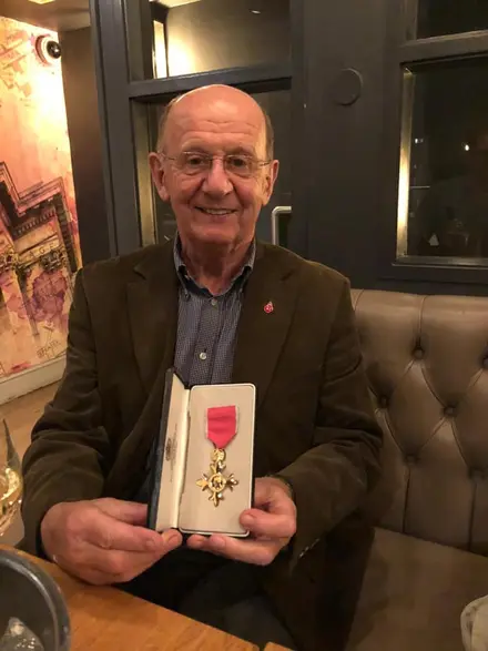 David Cole showing his OBE medal