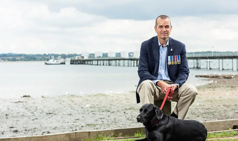 Charlie sat on beach with dog