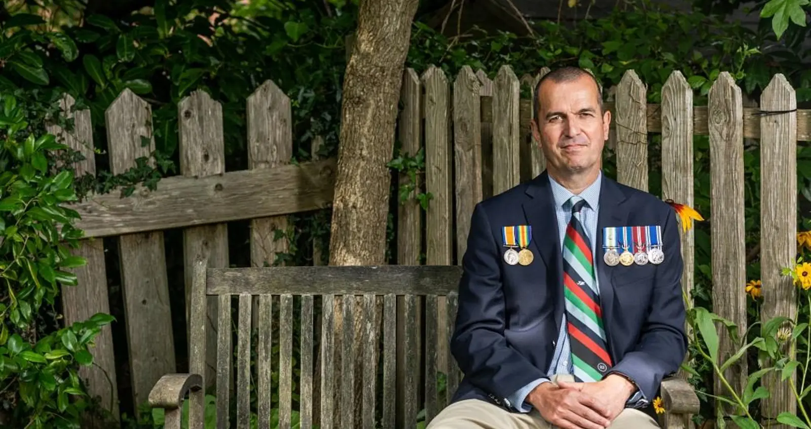 Charlie sat on bench wearing medals Charlie wearing medals