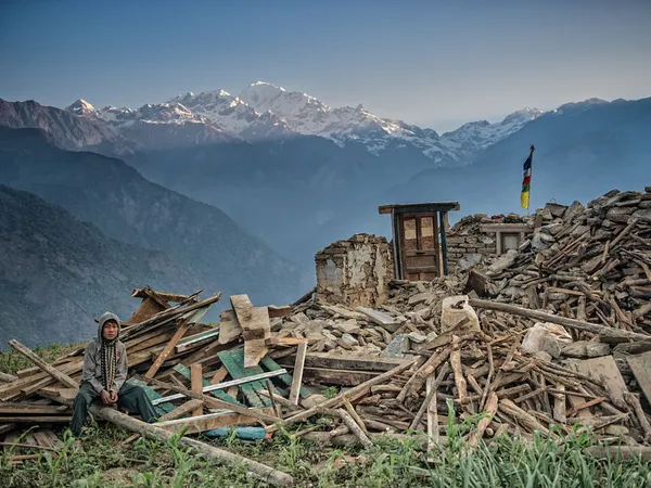 Gurkha veteran sitting in front of destroyed buildings