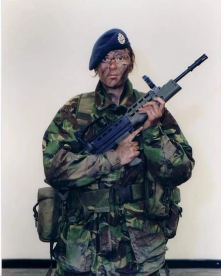 Screenshot_20230221_114822_Facebook Liz in full combat gear. She has paints smeared over her face and is holding a gun.