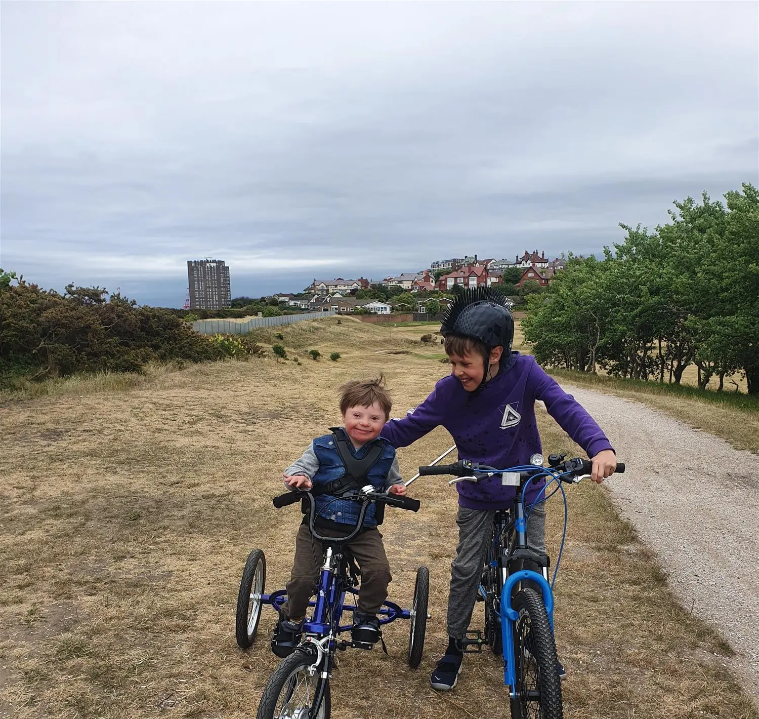 Jamie on his trike alongside his brother