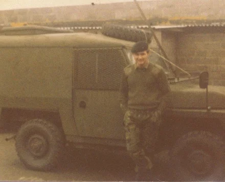 Julian leaning on a truck in his Army days