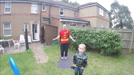 Lee and Noah in the garden dressed as superheroes