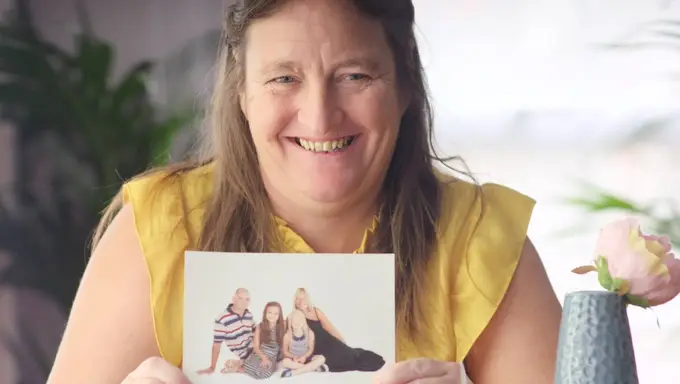 stories_chantelle_with_pic_smiling Chantele holding a picture of her family