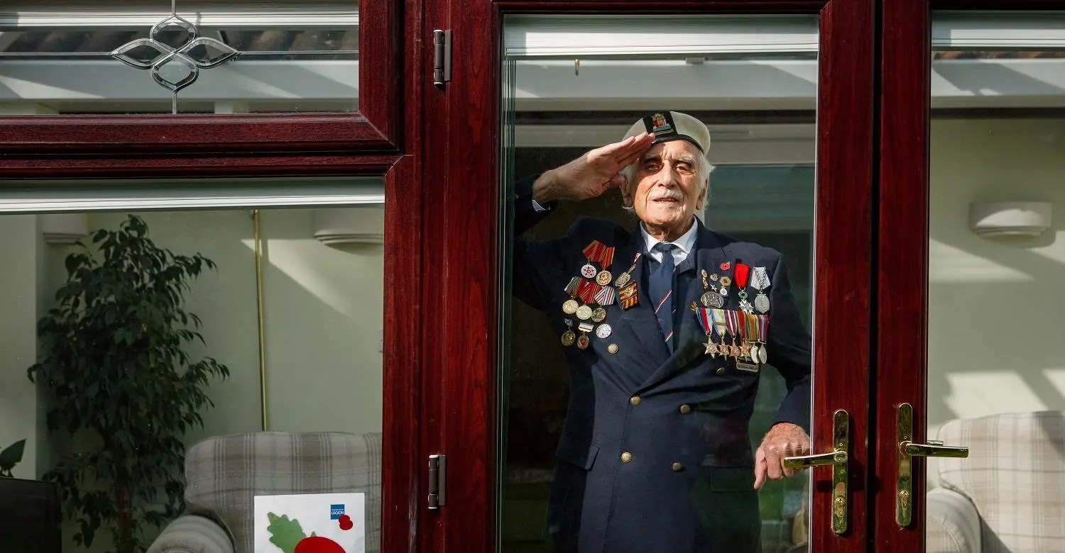 Bill Taylor saluting behind a window