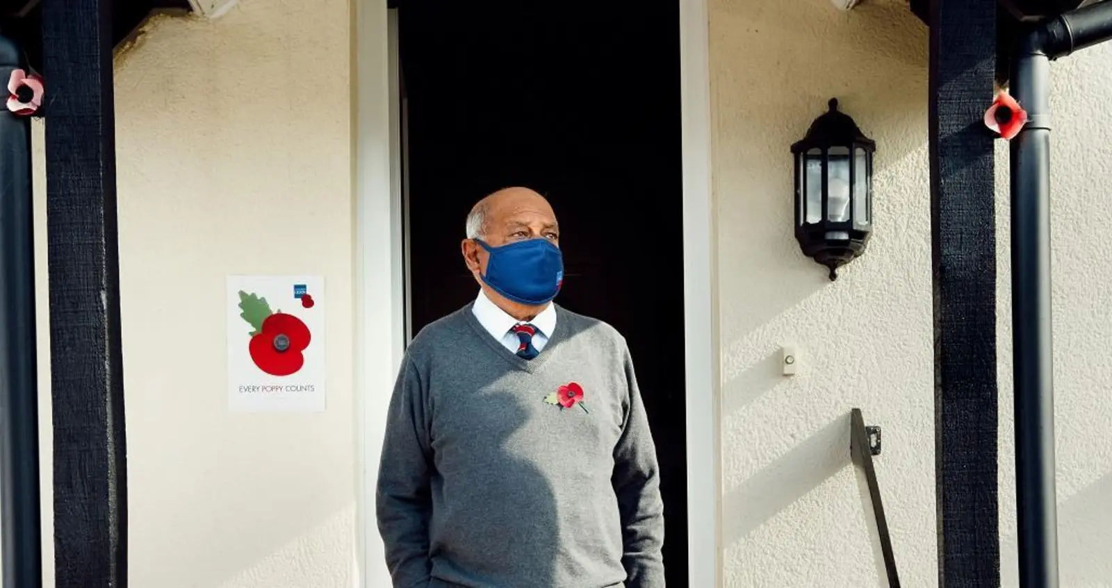 Flyle Hussain outside his house wearing a face mask