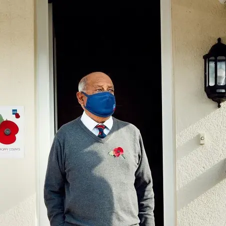 Flyle Hussain outside his house wearing a face mask