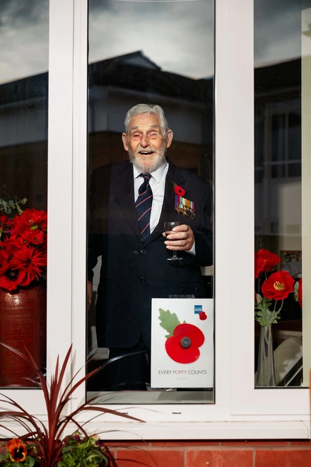 Ken Judd at his window with a poppy poster