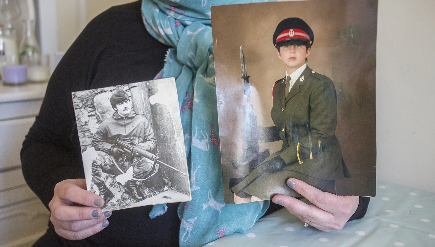 Stacey holding photos of her time in the Army