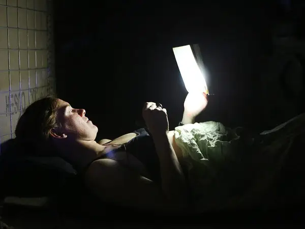 Life on base in Afghanistan, Anna Crossley reading a letter by torch light