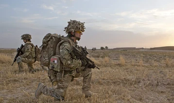 Anna Crossley in Afghanistan in battledress holding rifle