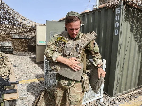 Anna Crossley in Helmand strapping on equipment vest