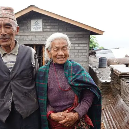 Baldhan and Budhini stood outside their newly build earthquake resistant home  Baldhan and Budhini stood outside their newly build earthquake resistant home