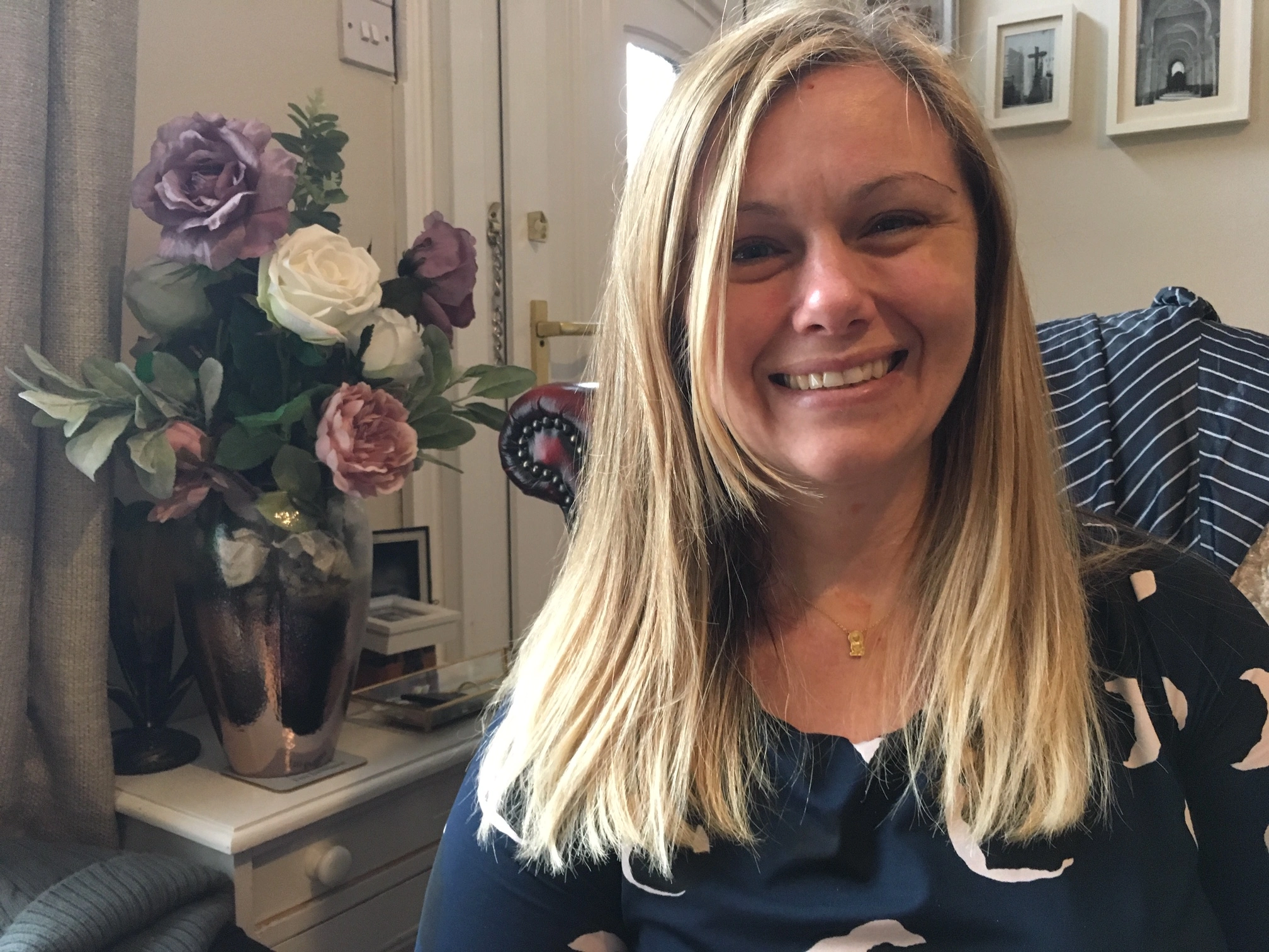 Naomi Hall sitting in a chair with flowers