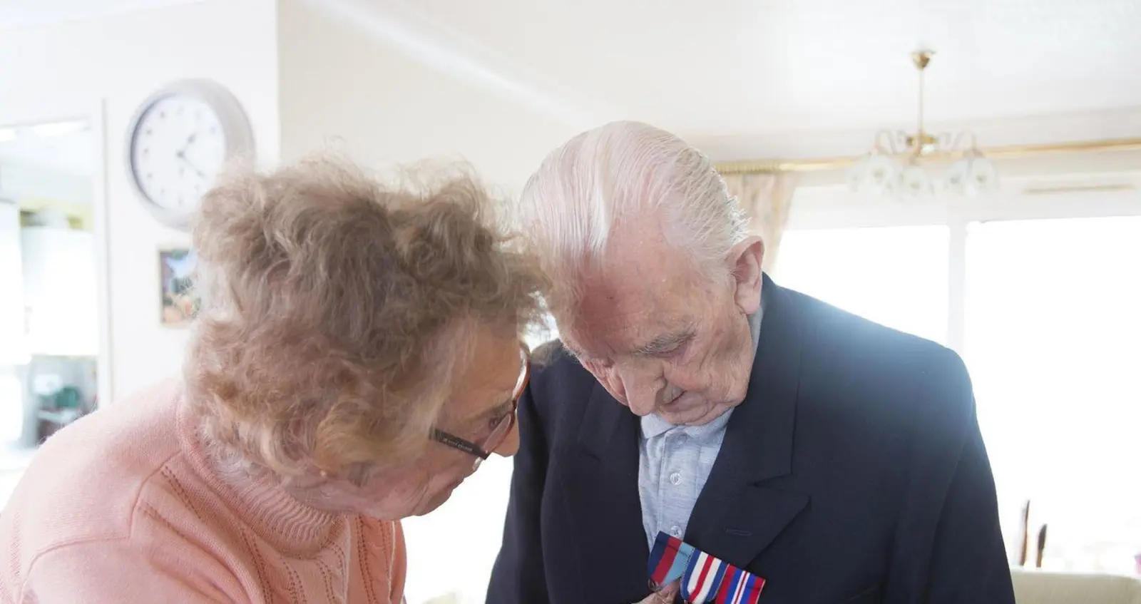 Veteran Reggie's wife helping him pin his medals