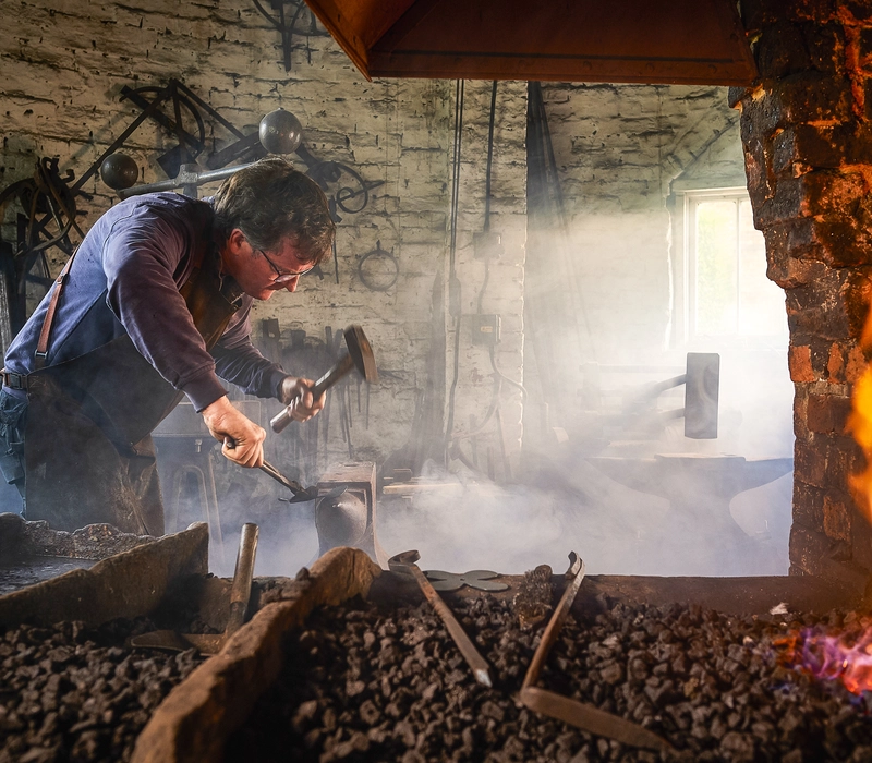 stories_tim_blacksmith_hammer_anvil Tim Mackareth in his workshop
