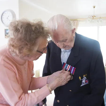 Stories_Veteran_Grows_Flowers_Reggie_Image4 Betty pinning Reggie's medals on his blazer