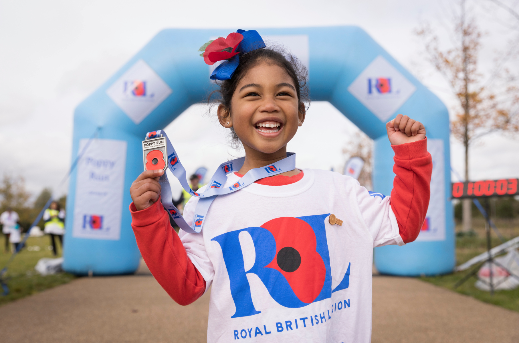 Girl showing off her Poppy Run medal