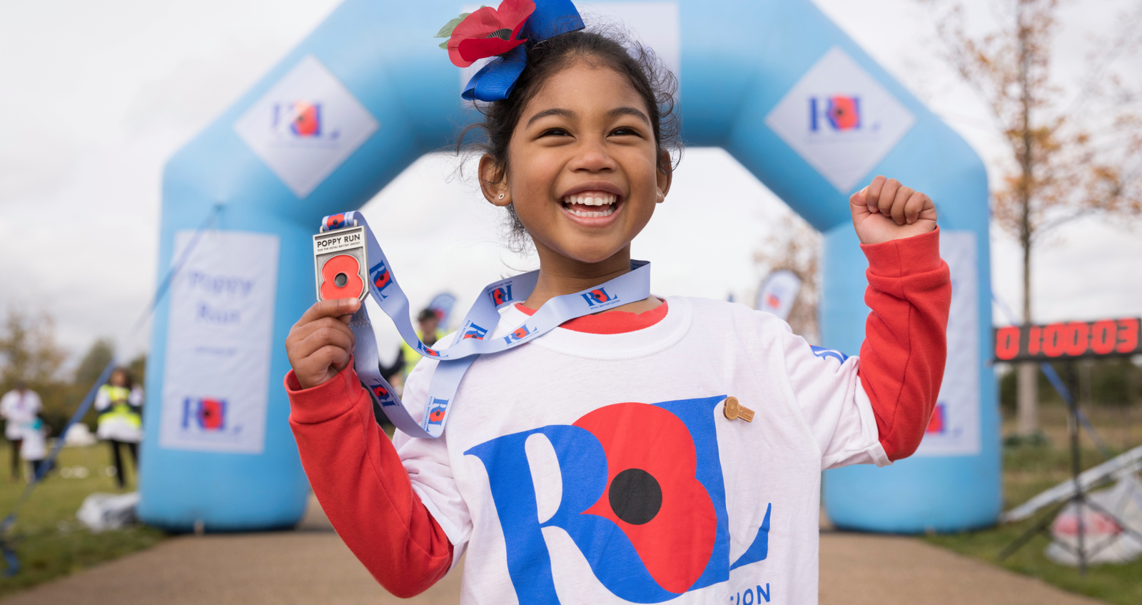 Girl showing off her Poppy Run medal