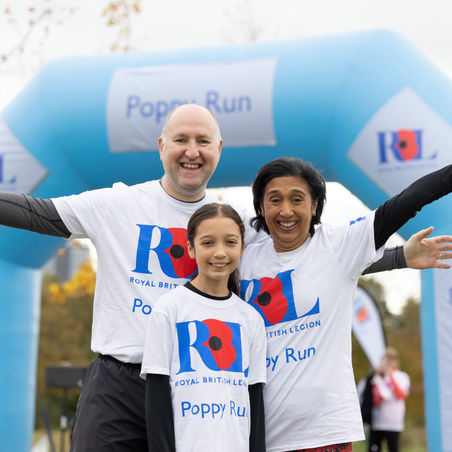 Family of three (father, mother and daughter) cheering at the Poppy Run entrance