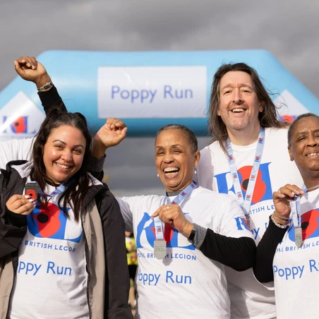 A group of Poppy Runners with their medals at the Poppy Run finish line