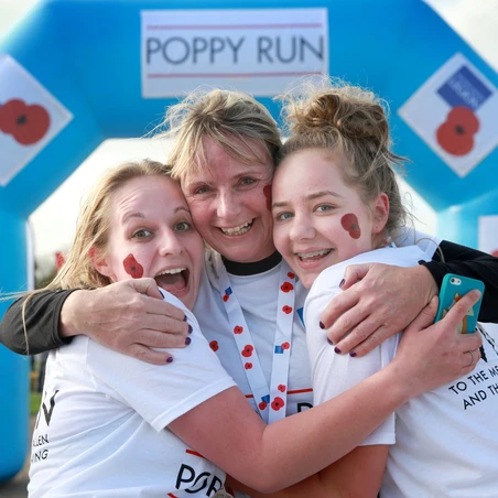Three Poppy Run London participants hugging at the end of the race.