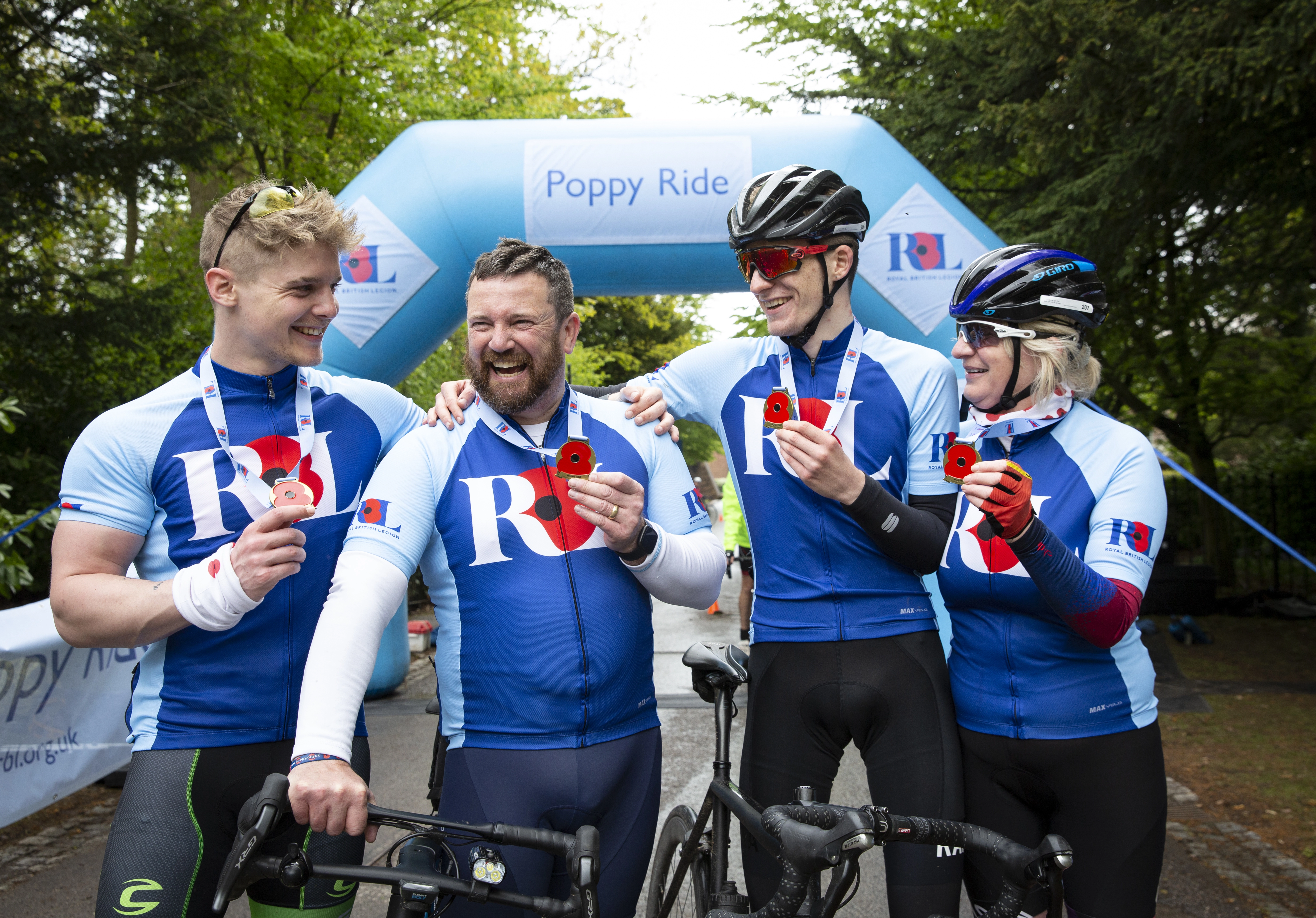 Cyclists cheering and showing their medals