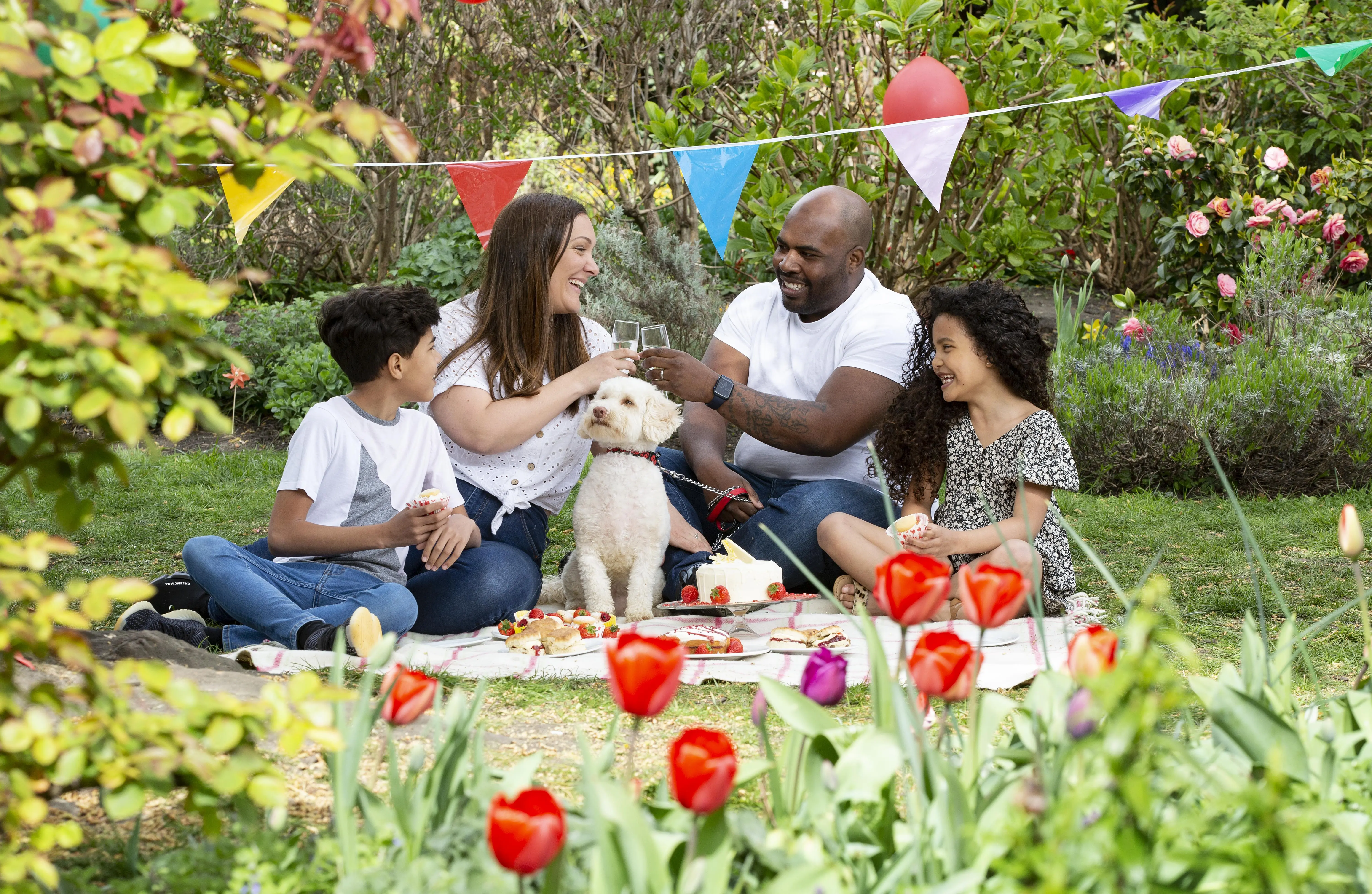 Family of four with dog enjoying a picnic