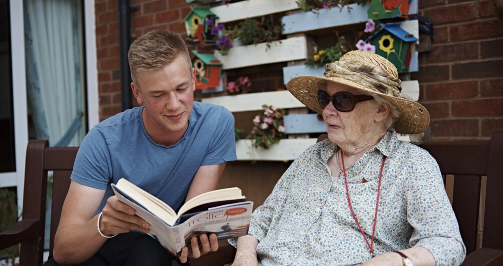 A young volunteer reading to a member of the Armed Forces community