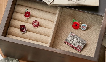 Box containing old photos and poppy pins